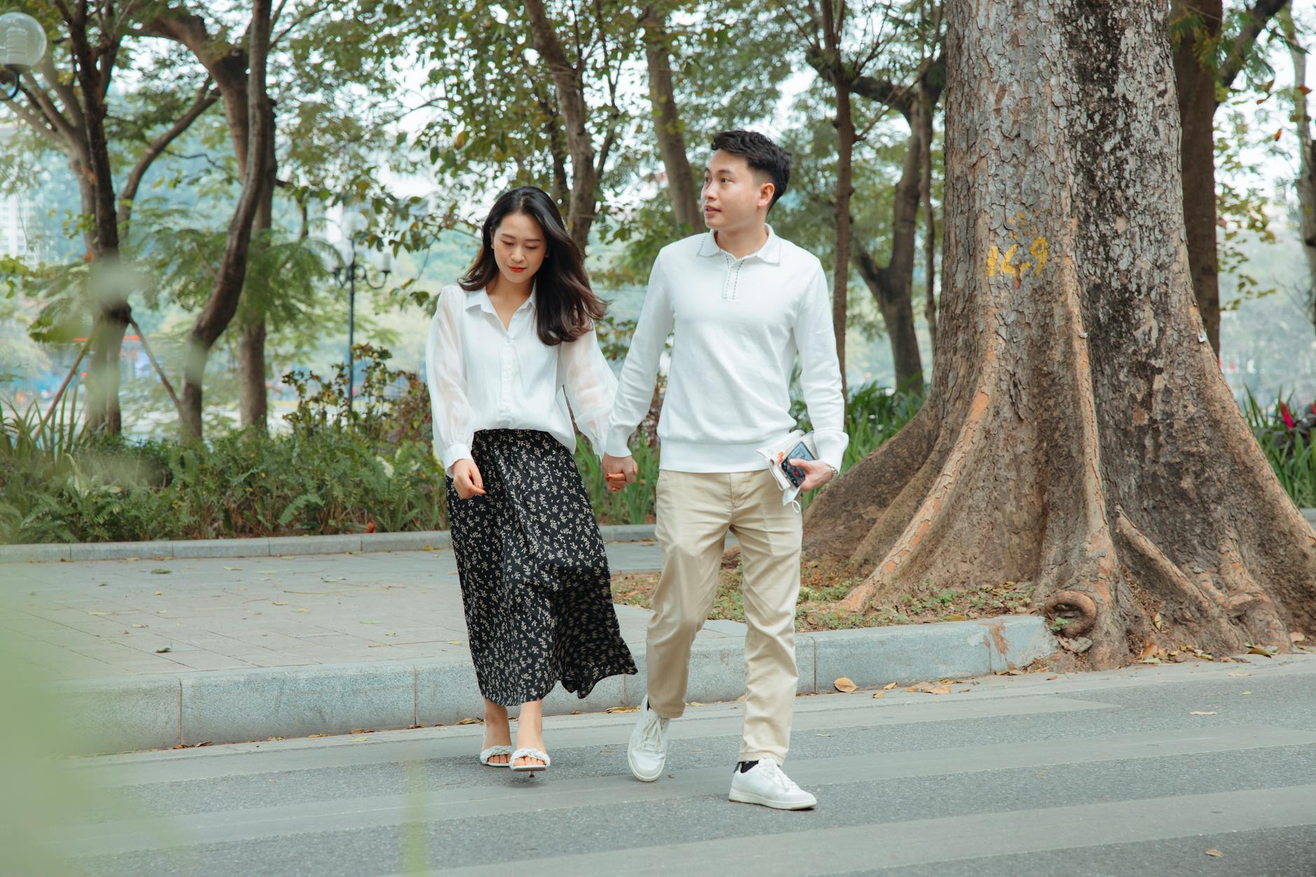 Comment reconnaître les signes physiques et émotionnels qui montrent que tu es amoureuse — couple se tenant la main dans un parc